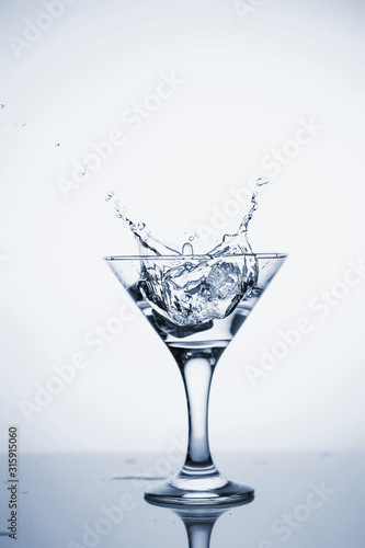 Clear mineral water is poured into a glass with ice.