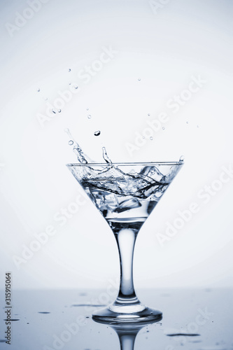 Clear mineral water is poured into a glass with ice.