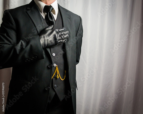 Portrait of Businessman in Dark Suit and Leather Gloves with Hand Over His Heart. Copy Space of Allegiance. Patriotic Duty. Solemn Oath. Copy Space.