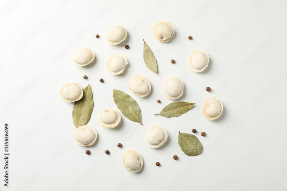Raw dumplings and spices on white background, space for text