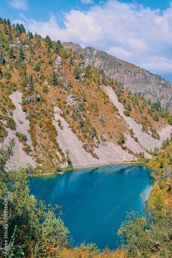 Obraz premium Lake in the mountains. Pond in the hills in Kyrgyzstan. Happy international mountain day.