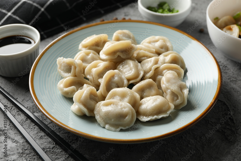 Composition with dumplings and soy sauce on grey background, close up Composition with dumplings and soy sauce on grey background, close up