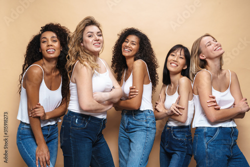 Image of beautiful multinational women laughing with hands crossed