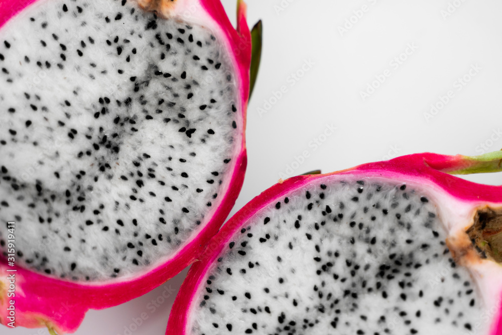 Dragon fruit. Vibrant Dragon Fruit on white background. Sliced white dragon fruit or pitaya on white plate on the table, close-up. Tropical and exotic fruits. Healthy and vitamin food concept. Dragon fruit. Vibrant Dragon Fruit on white background. Sliced white dragon fruit or pitaya on white plate on the table, close-up. Tropical and exotic fruits. Healthy and vitamin food concept.