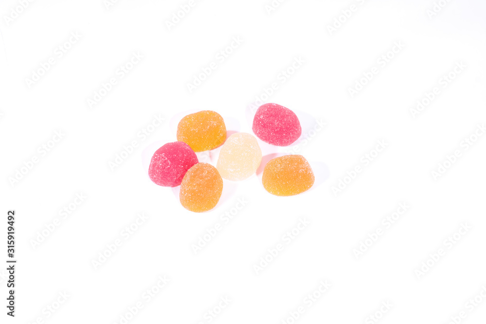 Multicolored tasty marmalades closeup on a white background. Multicolored tasty marmalades closeup on a white background.