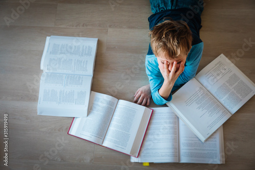 boy tired of reading, kid stressed by doing homework