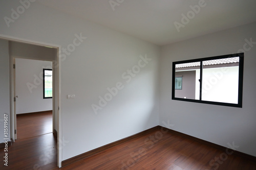 interior design empty room with white wall and wooden laminate floor in new residential house