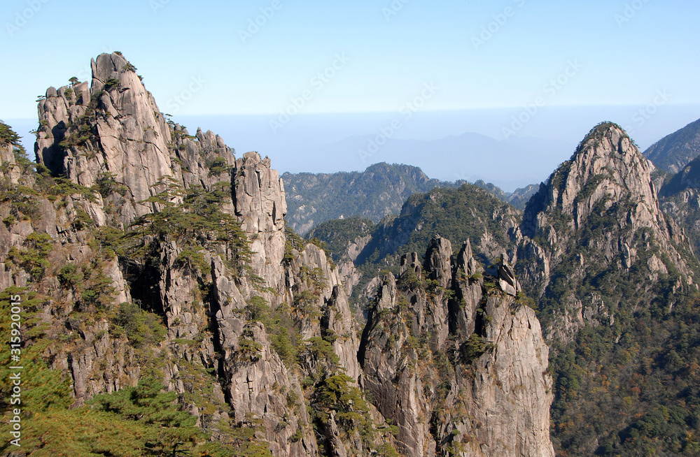 Huangshan Mountain in Anhui Province, China. A beautiful panoramic mountain view of the rocky peaks of Huangshan at White Goose Ridge. From a viewpoint near the summit of Huangshan Mountain, China.