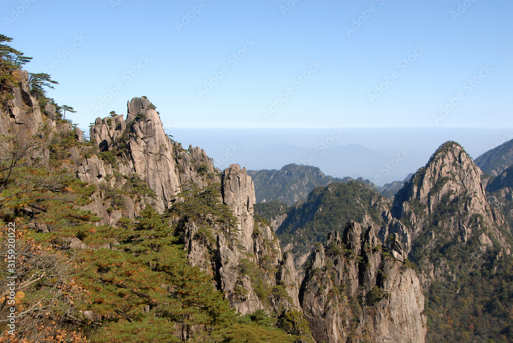 Huangshan Mountain in Anhui Province, China. A beautiful panoramic mountain view of the rocky peaks of Huangshan at White Goose Ridge. From a viewpoint near the summit of Huangshan Mountain, China.