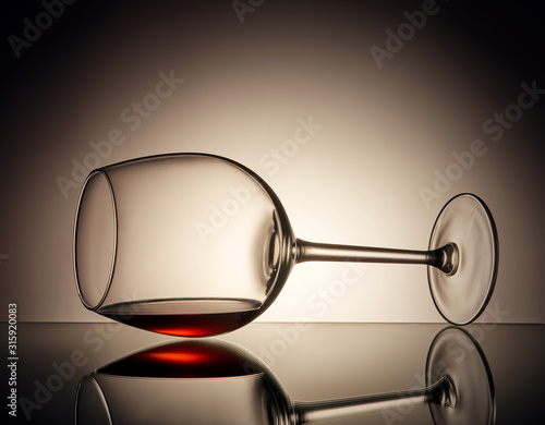 Kieliszek wina leży na szkle z odrobiną wina