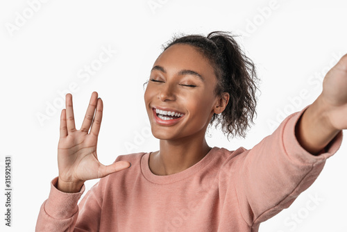 African american woman over isolated on white background and waiving friendly welcome gesture alien
