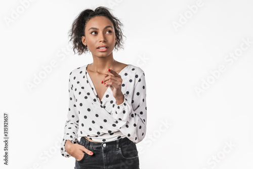 Attractive pensive young african woman in casual standing isolated over white background