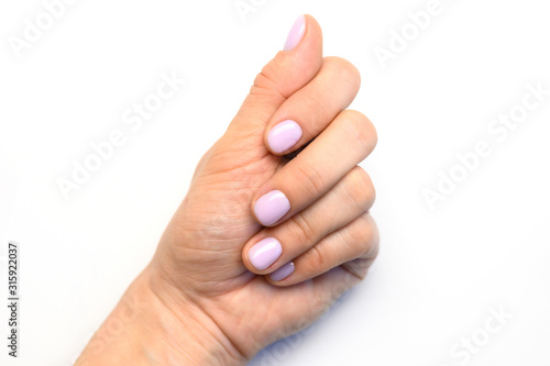 woman's hand with pale lilac painted nails on a white background