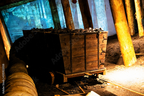 Coal mine underground railroad tunnel with carts filled with coal. photo