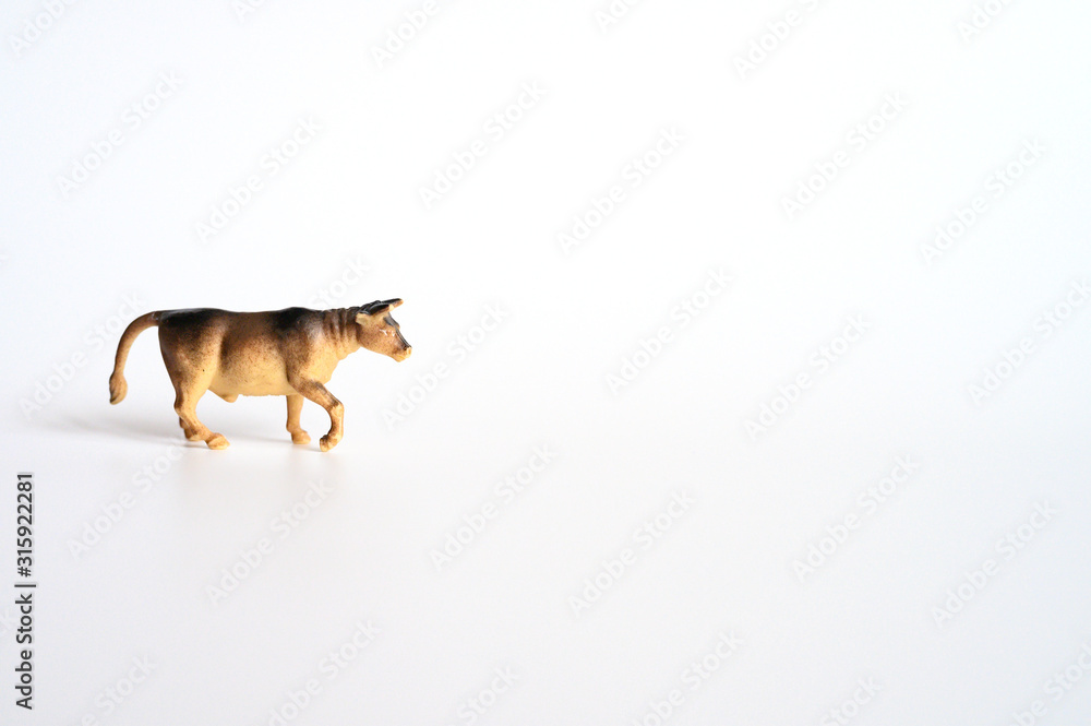 a small plastic toy figure of a bull is isolated on a white background. symbol of the year 2021 ox. space for text
