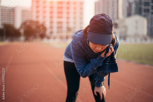 Tired woman runner taking a rest after running