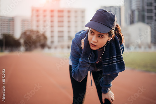 Tired woman runner taking a rest after running