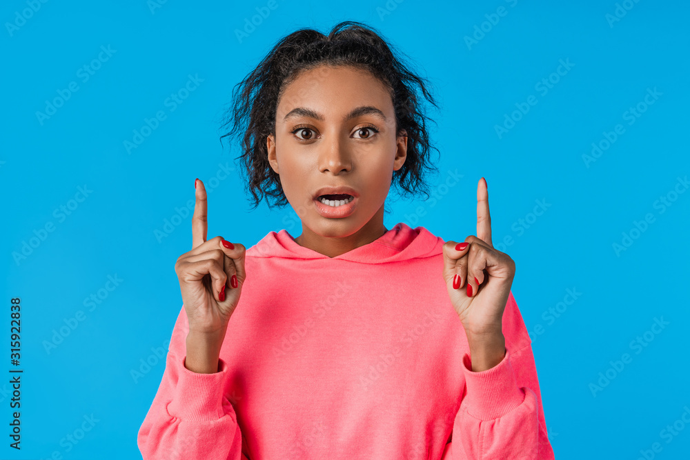 Beautiful african american woman with afro hair over isolated blue background pointing fingers up with idea Beautiful african american woman with afro hair over isolated blue background pointing fingers up with idea