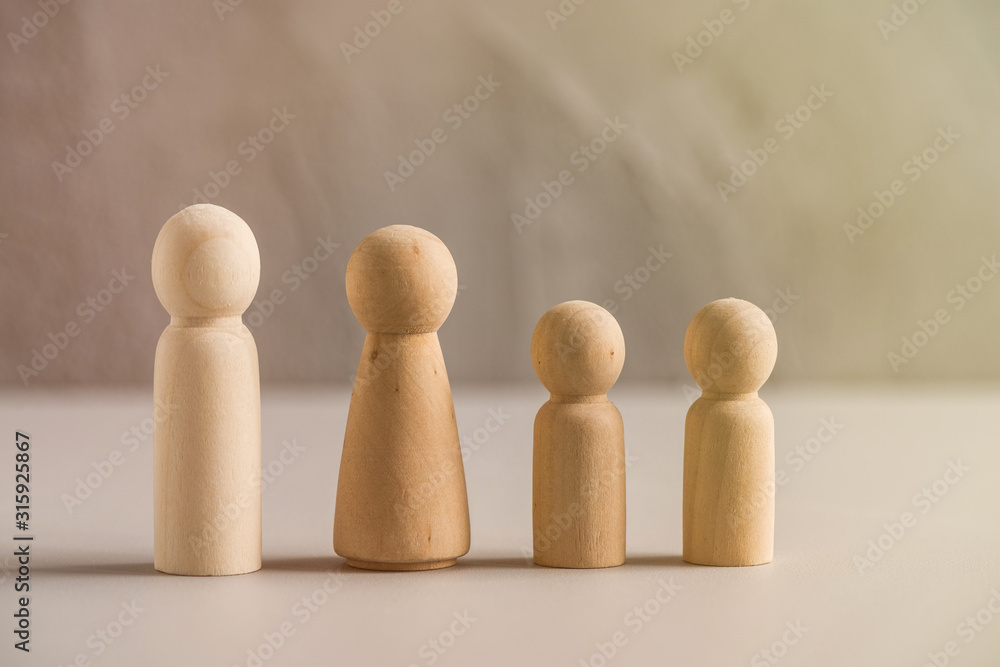 Wooden people man, woman and children against the background of a gray concrete wall. The concept and symbol of the large family. Family Care Concept Wooden people man, woman and children against the background of a gray concrete wall. The concept and symbol of the large family. Family Care Concept