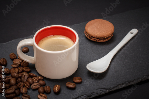 Cup of coffee and coffee beans on black background