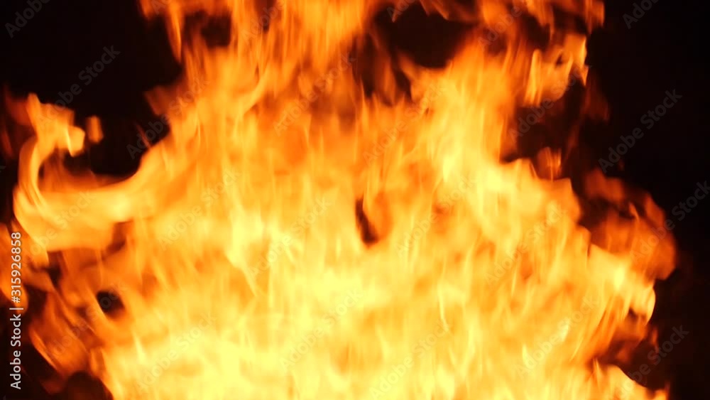 Wood burns in fireplace slow motion fire flames on dark background Wood burns in fireplace slow motion fire flames on dark background