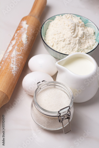 flour, eggs milk and sugar and rolling pin closeup