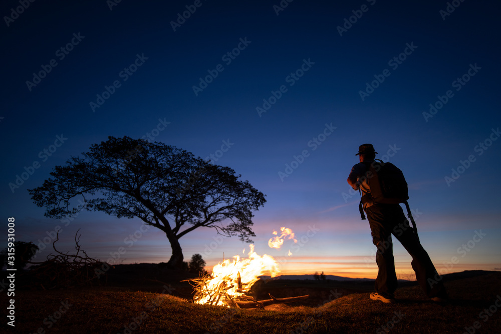 Silhouette of a lone man and a tree during sunset time