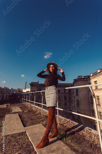 Fashion woman portrait of young pretty trendy girl in hat posing at the city in Europe, autumn street fashion. photo