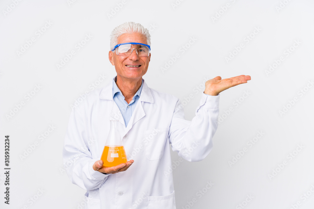 Mature chemical man isolated showing a copy space on a palm and holding another hand on waist. Mature chemical man isolated showing a copy space on a palm and holding another hand on waist.