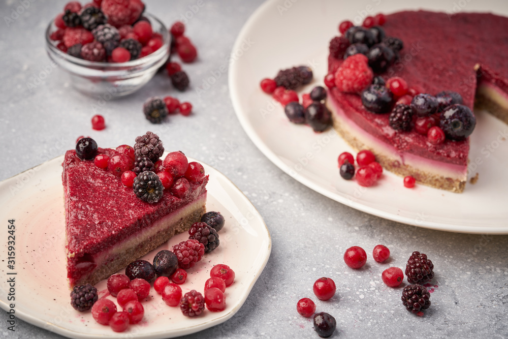 Raw vegan berry cherry cheesecake gluten-free on grey background. Raw vegan berry cherry cheesecake gluten-free on grey background.