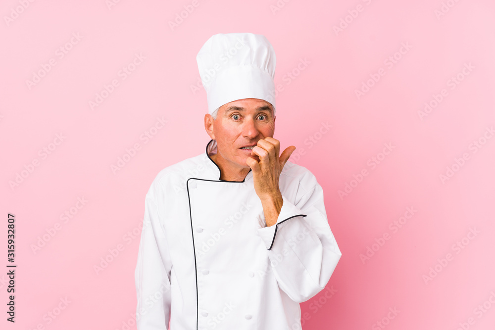 Middle aged cook man isolated biting fingernails, nervous and very anxious.