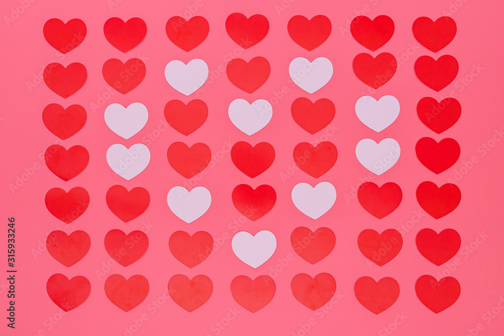 a lot of red small hearts put entire a picture and white small hearts put in a heart pattern, those are put on a pink background