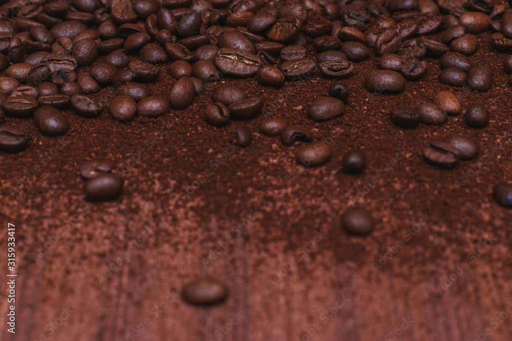 Coffee beans and ground coffee are scattered on a brown wooden background. Good morning to everyone who is in love with coffee. Coffee beans and ground coffee are scattered on a brown wooden background. Good morning to everyone who is in love with coffee.