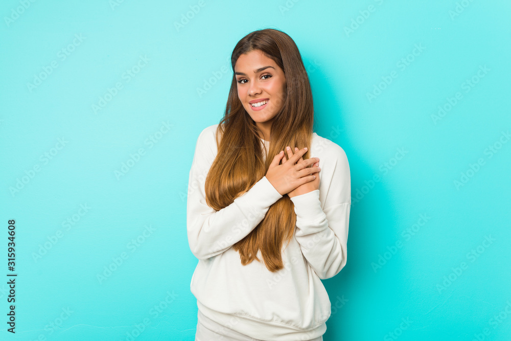 Young slim woman has friendly expression, pressing palm to chest. Love concept. Young slim woman has friendly expression, pressing palm to chest. Love concept.