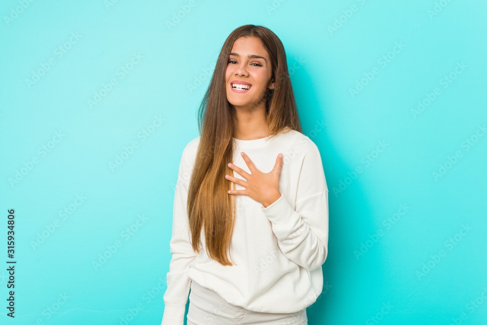 Young slim woman laughs out loudly keeping hand on chest. Young slim woman laughs out loudly keeping hand on chest.
