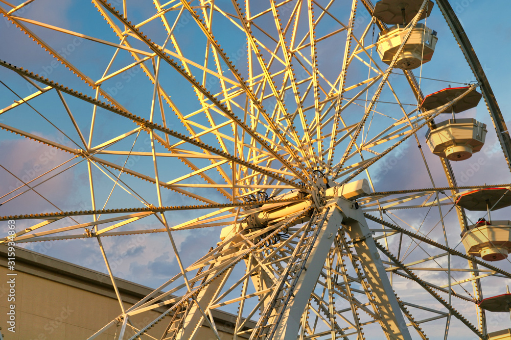 Fototapeta premium An old fashioned ferris wheel against a blue sky