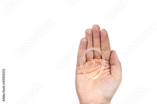 Birth control ring in a womans hand isolated on white background, vaginal ring for contraceptive use photo