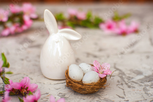 Spring conceptual photo with flowers. Flat lay blooming tree, easter eggs. The tree blooms pink and the eggs in the nest and copy space.