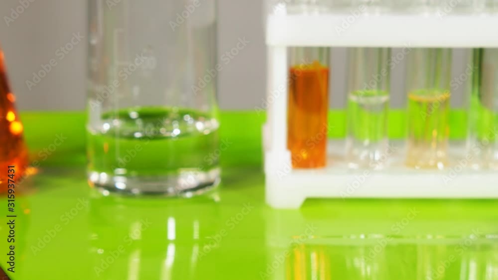 Test tubes, flasks and also other devices stand on the table in the laboratory.
