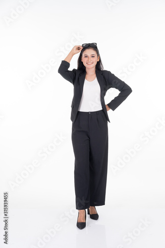 A portrait of a beautiful businesswoman in a black and white officewear and sunglasses isolated on white background.