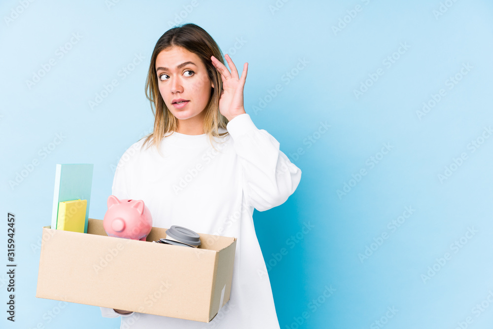 Young caucasian woman moving home isolated trying to listening a gossip. Young caucasian woman moving home isolated trying to listening a gossip.