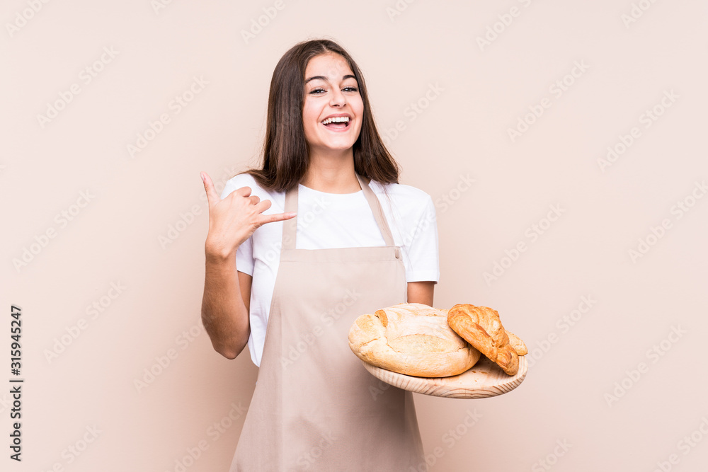 Young caucasian baker woman isolated showing a mobile phone call gesture with fingers. Young caucasian baker woman isolated showing a mobile phone call gesture with fingers.