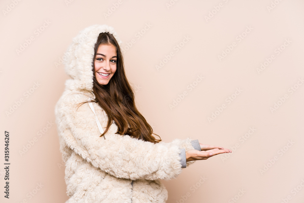 Young caucasian woman posing isolated holding a copy space on a palm. Young caucasian woman posing isolated holding a copy space on a palm.