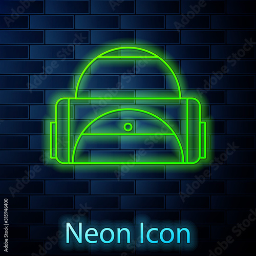 Glowing neon line Sport bag icon isolated on brick wall background. Vector Illustration