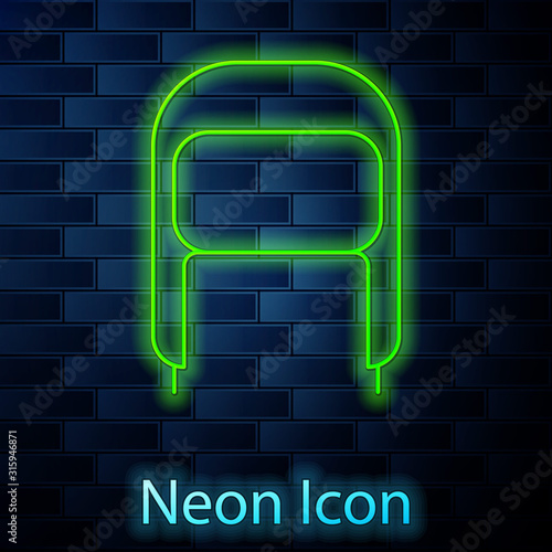 Glowing neon line Winter hat with ear flaps icon isolated on brick wall background. Vector Illustration