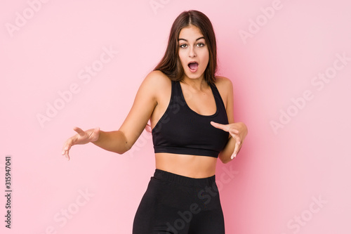 Young caucasian fitness woman doing sport isolated being shocked due to an imminent danger