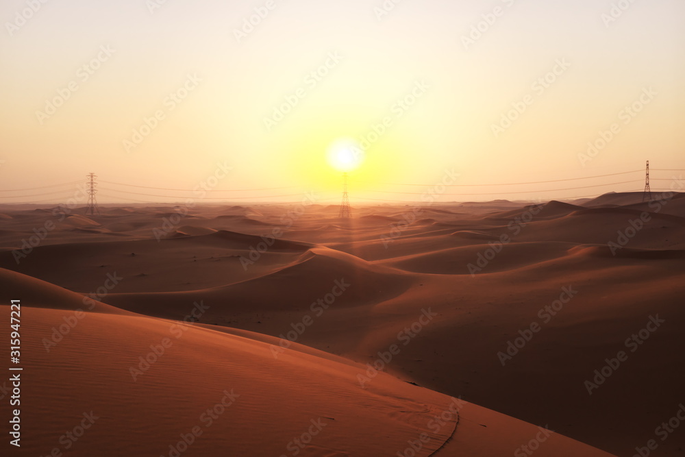Desert sunrise with power transmission towers and lines for solar energy concept. Riyadh, Saudi Arabiar 
