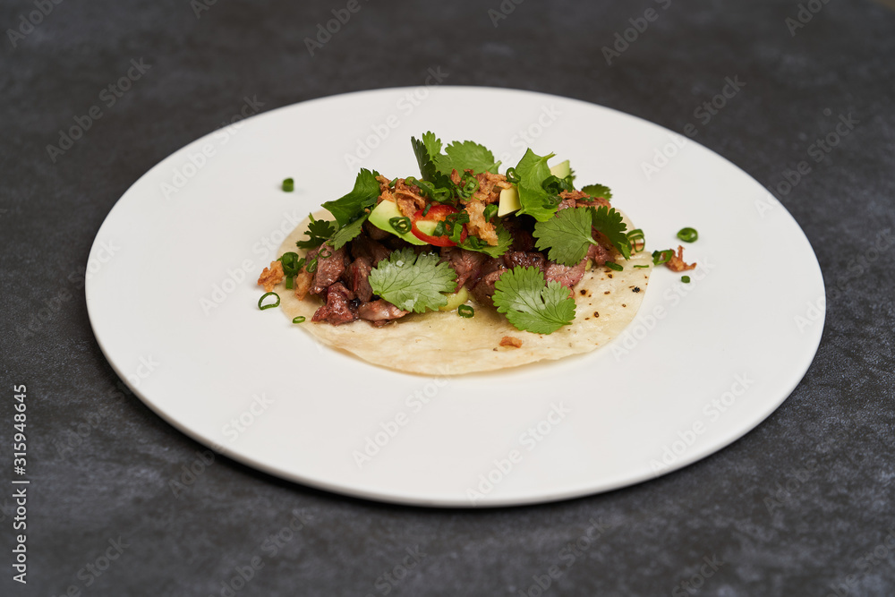 Pork carnitas street tacos, close-up. Mexican tacos with beef, tomatoes, avocado, chilli and onion Pork carnitas street tacos, close-up. Mexican tacos with beef, tomatoes, avocado, chilli and onion
