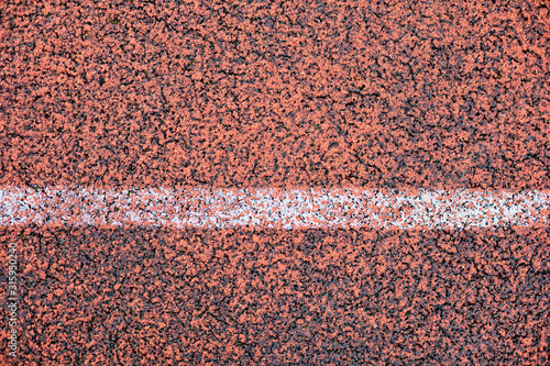 Basketball court covered with red rubber crumb with marking