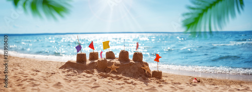 Sandcastle on the blue sea in summertime